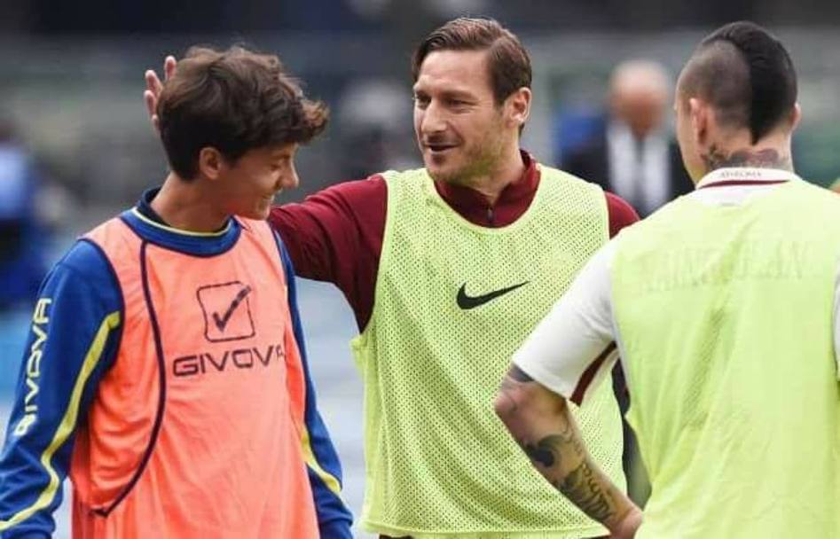 Simpatico siparietto durante Chievo-Roma. Protagonisti Francesco Totti, 40 anni e un baby calciatore del Chievo, nemmeno 17enne. 